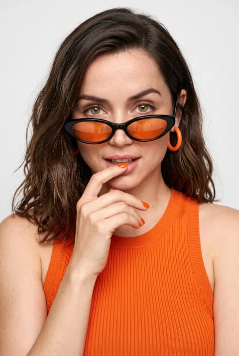 Ana de Armas — orange-accent high-key portrait, AI-generated