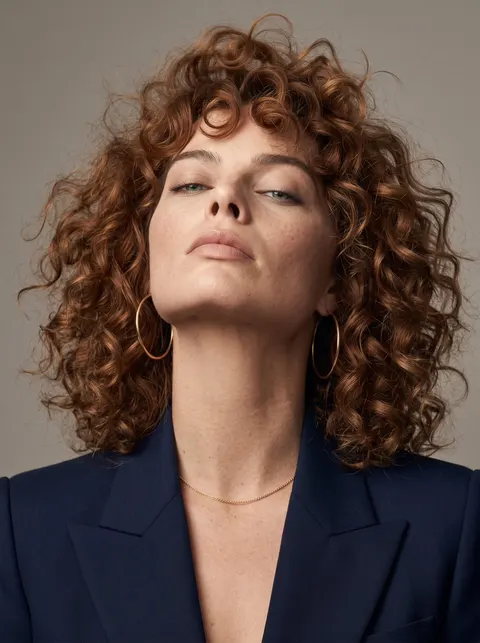 Margot Robbie — voluminous curls and navy blazer portrait, AI-generated